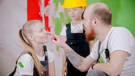 Happy family having fun while painting walls in new houseの写真素材