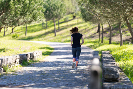 Fitness concept - an adult woman jogging in the parkの写真素材