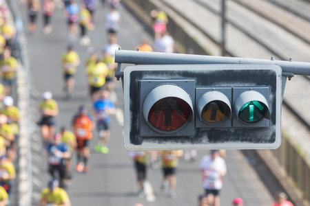Traffic light in the foreground - people running a half marathon on the bridgeの写真素材