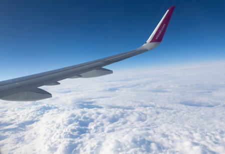 5 April 2023 Belgrade, Serbia: view from the airplane window on the wing of the aircraft and fluffy clouds - wizz air air companyのeditorial素材