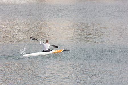 A woman rowing in a canoe at marina