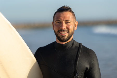 Smiling man surfer in a wetsuitの写真素材