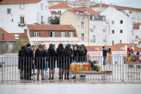 21 April 2023 Lisbon, Portugal: Alfama - Group of girls students celebrate the student holidays with many homemade alcohol drinksのeditorial素材