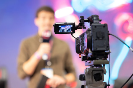 A movie camera shoots a man on stage at the game expoの写真素材