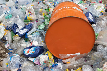 16 october 2022 Almada, Portugal: GALP orange barrel laying on top of landfill of plastic garbageのeditorial素材