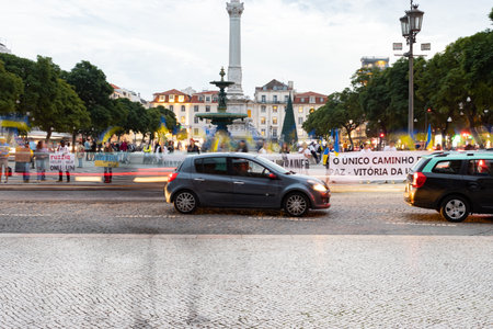 10-29-2022 LISBON, PORTUGAL: Ukrainian protest at Lisbon Square next to the roadway - a car drives past people holding postersのeditorial素材