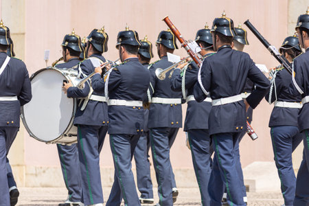 A military orchestra plays on the street during the parade - view from the back