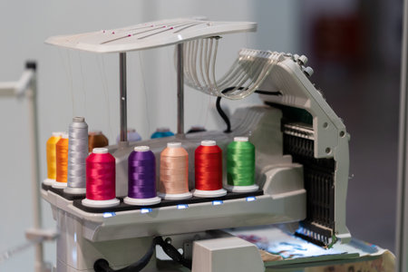 Multi-colored spools of thread are connected to an embroidery machineの写真素材