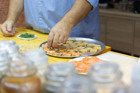 Sushi chef placing toppings on sushi rolls