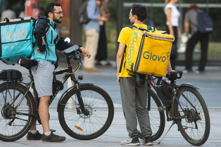 29 september 2023, Belgrade, Serbia - two men on bicycles - carriers of Glova and walt have conversation on the streetのeditorial素材