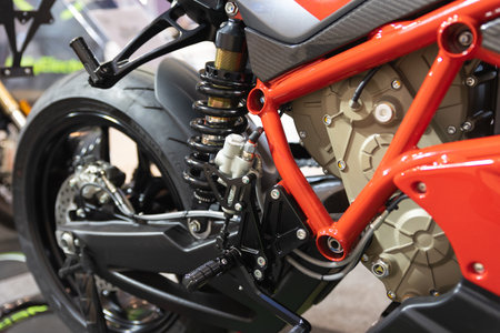 A Close Up of a Motorcycle Parked in a Garage with Electric Cars