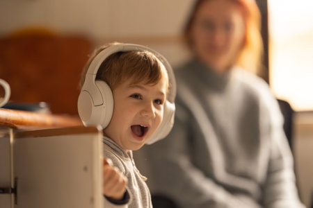 A Boy Listening to Music with a Woman in the Backgroundの写真素材