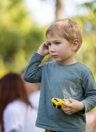 A young boy is holding a toy car