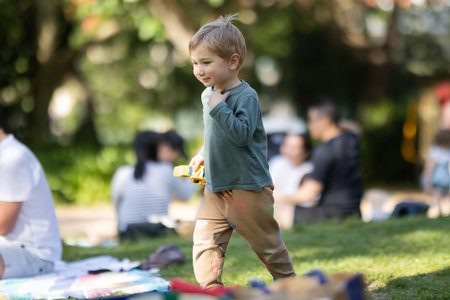 A young boy is playing with a toy car in a park