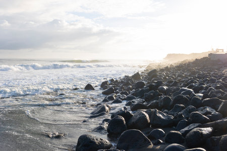 The beach is rocky and the water is choppyの写真素材