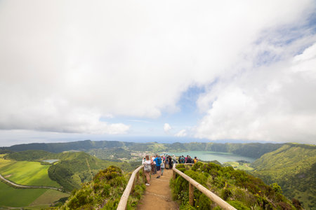 A group of people are walking on a path up a mountainの写真素材