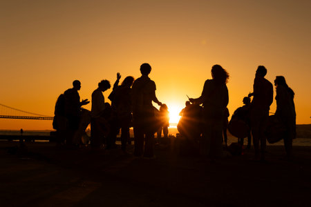 A silhouette of drum players musicians against a sunset