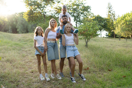 Happy family posing together in a park during summer vacationの写真素材