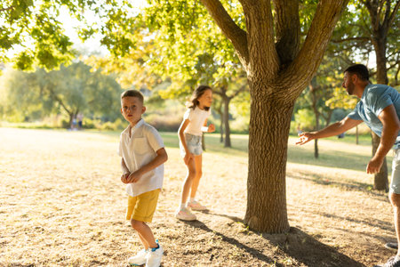 Family playing hide and seek in a sunny park