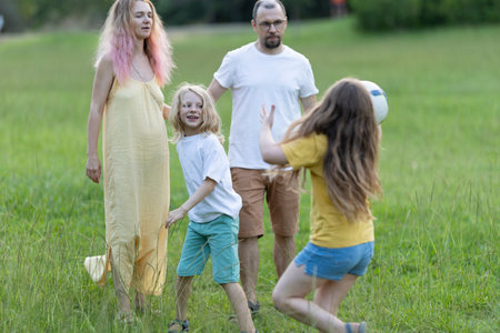 Happy family playing ball in the park on summer dayの写真素材