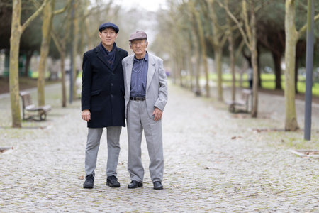 Asian father and son posing together in parkの写真素材
