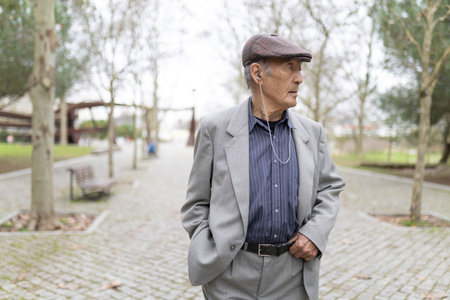 Elderly gentleman listening to music while walking in park