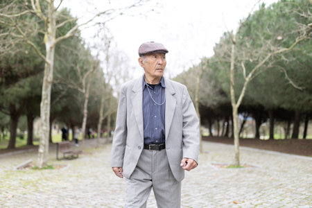 Elderly man enjoying a relaxing walk in the parkの写真素材