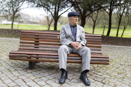 Senior man enjoying music in a peaceful park settingの写真素材