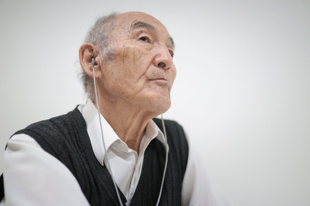 Senior man listening to music with earphones, enjoying technologyの写真素材