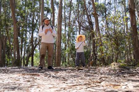 Father and son exploring nature, enjoying a sunny day in the woods