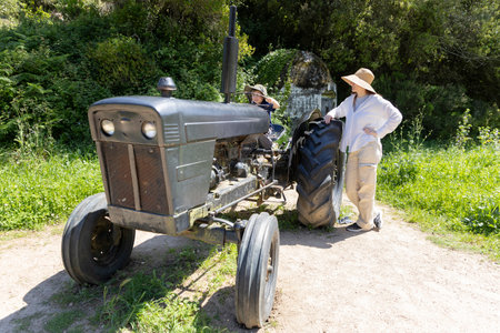 Farmers family taking a break near their tractor in a field