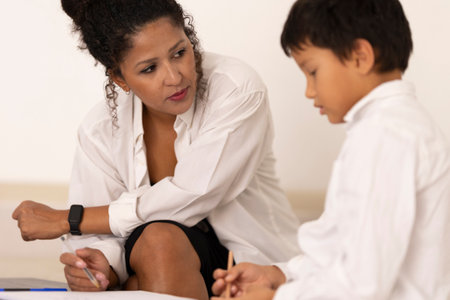 Child psychologist assisting young boy during therapy session