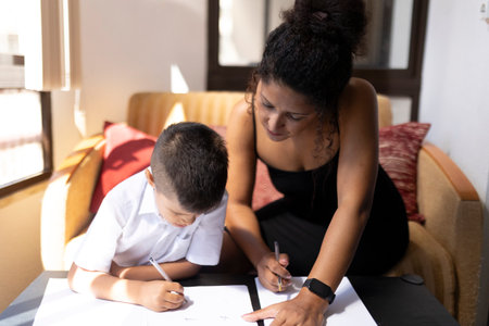 Mother helping son with homework, homeschooling during quarantineの写真素材