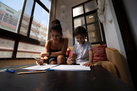 Mother and son drawing together at home, enjoying quality time