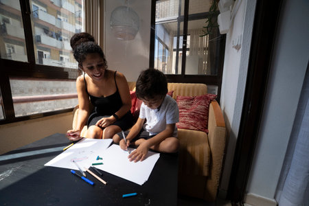 Mother and son drawing together at home, enjoying quality timeの写真素材