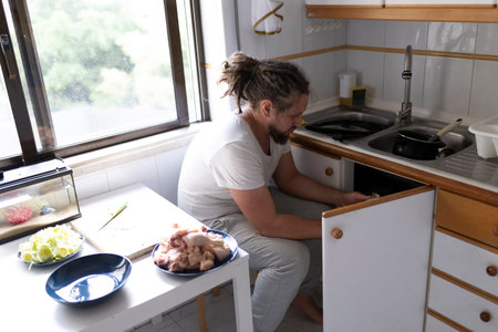 Man composting organic chicken waste in his home kitchenの写真素材