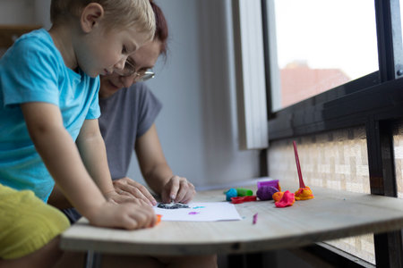 Child and teacher sculpting colorful clay figures in art classの写真素材
