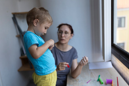 Child playing with modeling clay with teacher at art schoolの写真素材