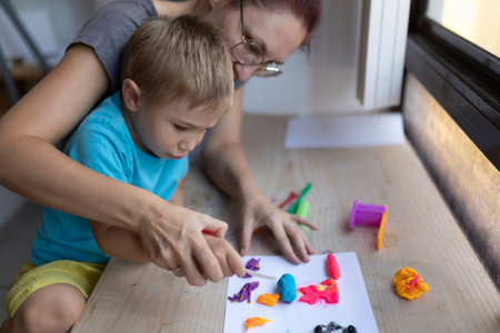 Mother and son creating colorful artwork with modeling clayの写真素材