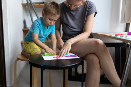 Mother and son creating colorful clay art at homeの写真素材