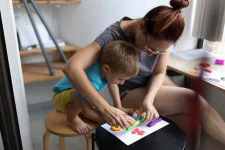 Mother and son creating colorful clay shapes at homeの写真素材