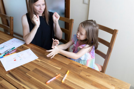 Speech therapist helping young girl with pronunciation and communication skillsの写真素材