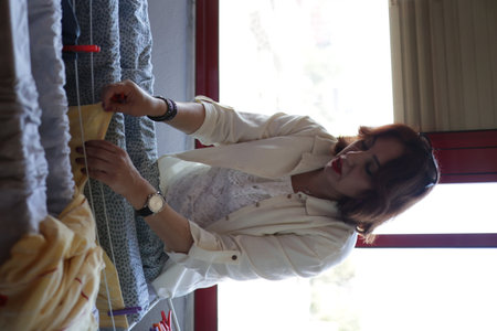 Woman hanging wet clothes on a clothesline indoorsの写真素材