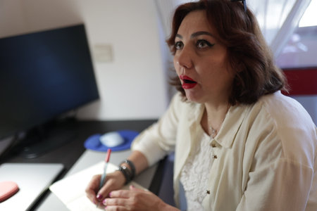 Businesswoman taking notes and looking up with an amazed expressionの写真素材