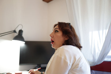 Woman working from home is having a revelation while taking notesの写真素材