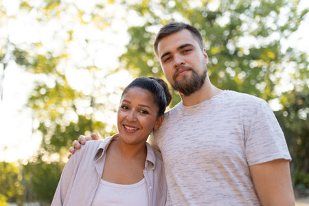 Interracial couple smiling and embracing in a parkの写真素材