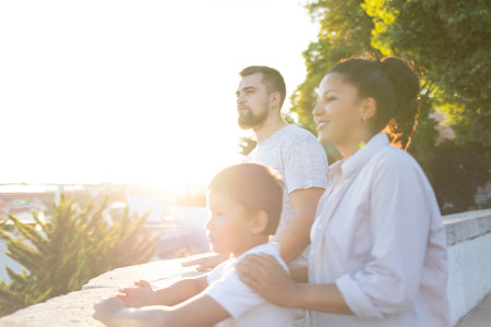 Happy family watching sunset from city wall at golden hourの写真素材