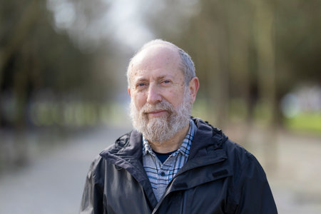 Portrait of smiling senior man enjoying retirement in park