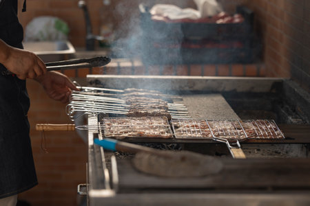 Chef grilling meat skewers and pieces of chicken or pork on barbecue grillの写真素材