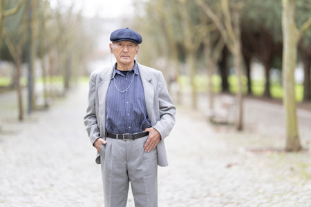 Senior man posing in a cobblestone path with treesの写真素材